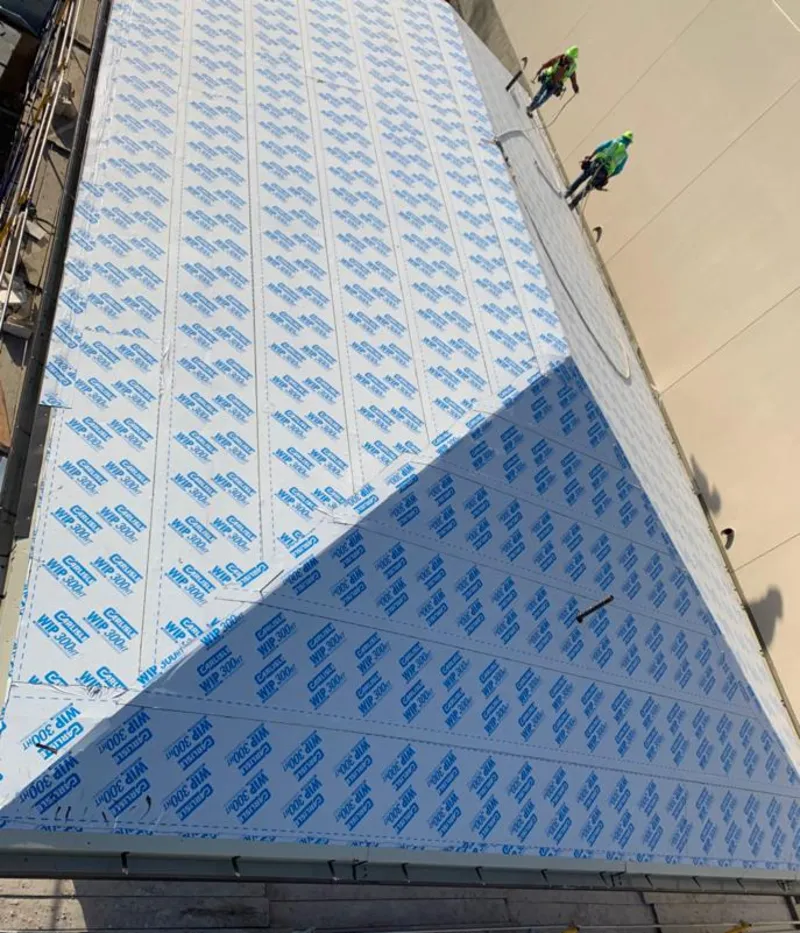 Professional roofers installing underlayment on a metal roof in Lower Moreland